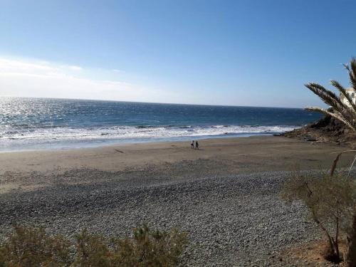 Playa del AguilaにあるApartment Sun Clubの海沿いの海岸を歩く2名