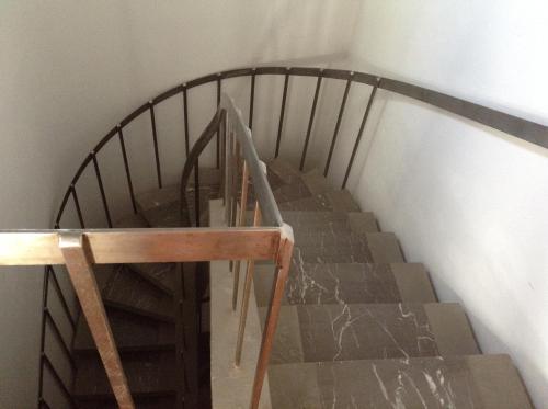 a staircase with a wooden rail and a wooden table at Appartamenti Villa Abbraccio in Siena