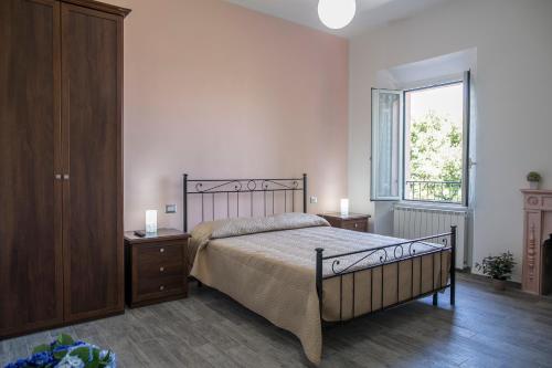 1 dormitorio con 1 cama, vestidor y ventana en La Sosta B&B, en Stroncone