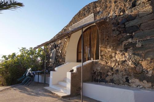 een gebouw met een trap en een stenen muur bij La Palma in Pantelleria