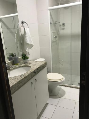 a bathroom with a toilet and a sink and a shower at Apartamento Barra Bali in Barra de São Miguel