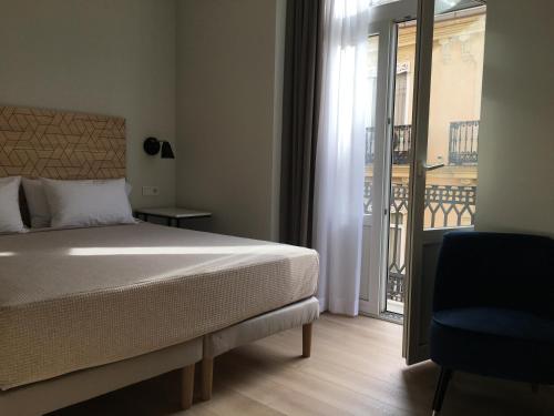 a bedroom with a bed and a view of a balcony at MD Design Hotel - Portal del Real in Valencia