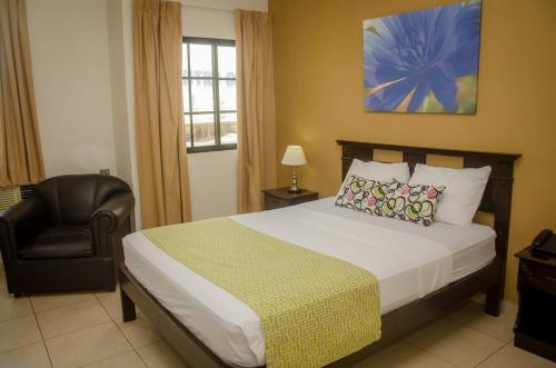 a hotel room with a bed and a chair at Hotel Residencial Cervantes in David