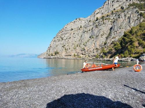 a group of people on a beach next to a boat at Hotel Gabbiano in Maratea