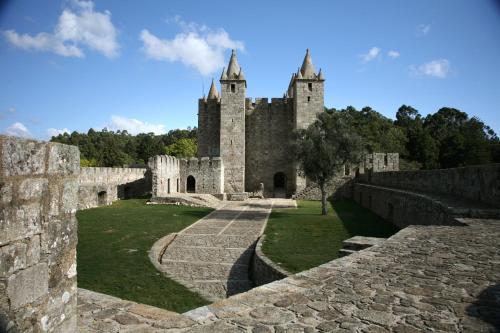 an old castle with a stone wall and trees at Hotel ibis Porto Sul Europarque in Santa Maria da Feira