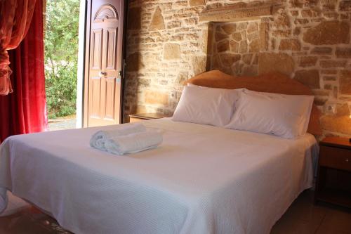 a bedroom with a bed with two towels on it at Villa Fabrika in Vóroi