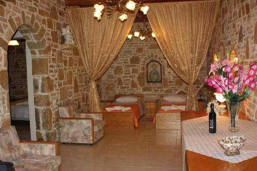 a room with a stone wall with tables and chairs at Villa Fabrika in Vóroi