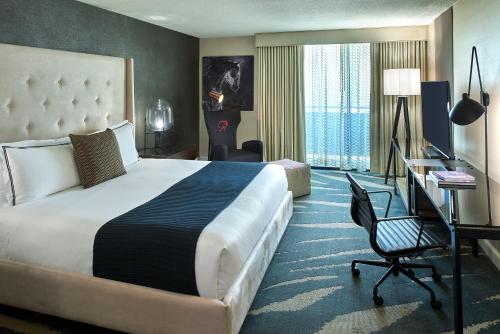 a hotel room with a large bed and a desk at Revere Hotel Boston Common in Boston