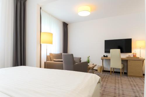 a hotel room with a bed and a desk at Hotel zum Kuhhirten in Bremen