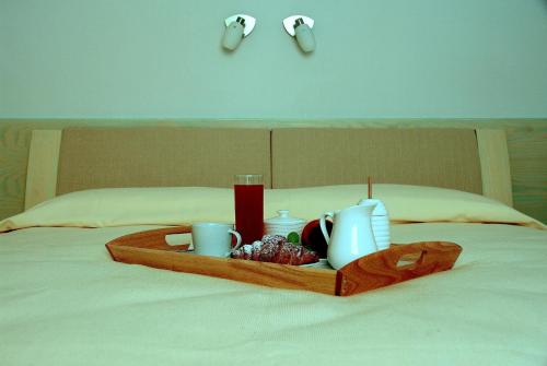 a tray with cups and cups on a bed at La Casa di Boz B&B in Nuoro
