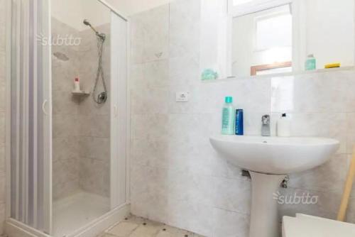 a white bathroom with a sink and a shower at Casa Santa Barbara in Modica
