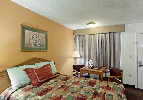 a hotel room with a bed and a desk at Rodeway Inn in Canton