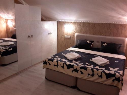 een slaapkamer met een bed met een zwart-wit dekbed bij Anasera in Tbilisi City