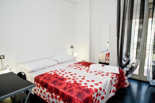 a bedroom with a bed with a red and white blanket at B&B Etna's Tourist in Catania