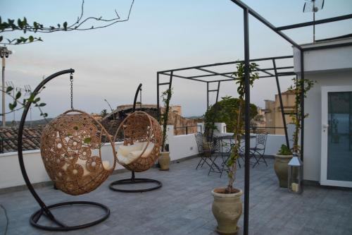 a balcony with baskets and potted plants on a building at Ziolì in Noto