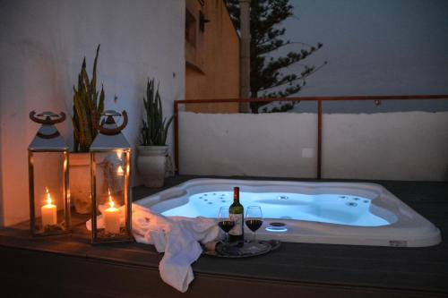 a bath tub with a bottle of wine and candles at Ziolì in Noto