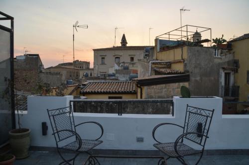 two chairs on a balcony with a view of a city at Ziolì in Noto