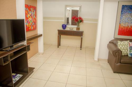 a living room with a couch and a television at Hotel Residencial Cervantes in David
