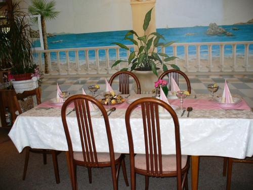 a table with chairs and a table with pink napkins at Villa Hawaii in Rapotín