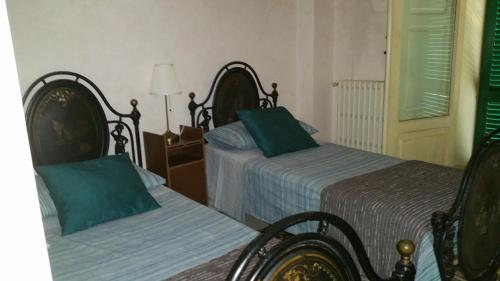 a bedroom with two beds with green pillows at Palazzo Lagioia in Triggiano