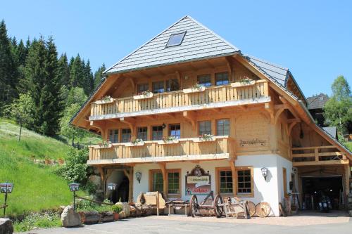 a large wooden house with a balcony on top at Hotel & Restaurant Grüner Baum - Die Grüne Oase Am Feldberg in Feldberg