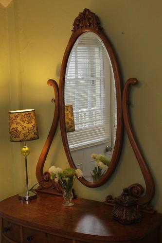 a mirror sitting on top of a wooden table at Glass Magnolia Bed & Breakfast in Interlaken