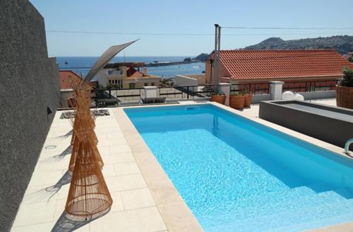 a swimming pool on the roof of a house at Quinta B. in Funchal