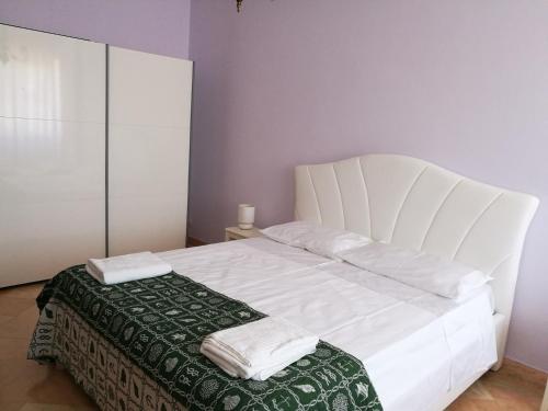Una cama blanca con dos almohadas encima. en B&B Domus Lupiae, en Lecce