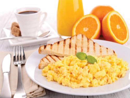 a plate of eggs and toast and a cup of coffee at Casa Santiago Mayor in Cali