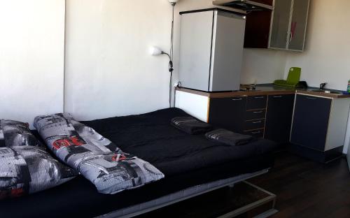 a small kitchen with a black bed in a room at Walk distance to mokotow business park in Warsaw