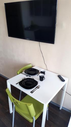 a white table with a stove and a tv on a wall at Walk distance to mokotow business park in Warsaw