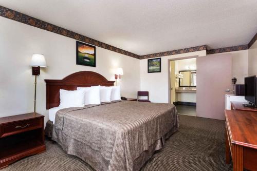 a hotel room with a bed and a television at Heritage Inn Augusta in Augusta
