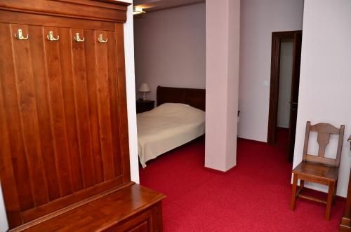 a bedroom with a bed and a wooden closet at Pensiunea Valea Pinului in Rau Sadului
