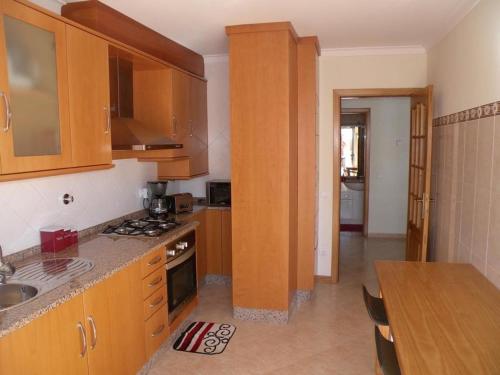 a kitchen with wooden cabinets and a counter top at AS 3 GAIVOTAS in Vila Praia de Âncora