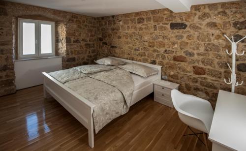 a bedroom with a bed and a brick wall at Apartment Antea in Sinj