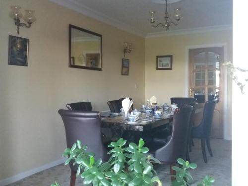 a dining room with a table and leather chairs at Villa Pio Accommodation Cong in Cong