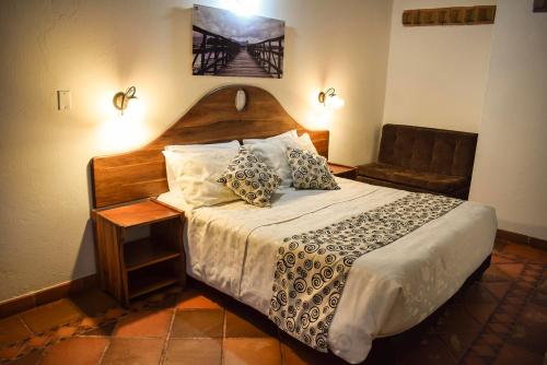 a bedroom with a large bed and a chair at Hotel Hacienda Santa Cecilia in Sáchica