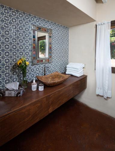 a bathroom with a wooden counter with a mirror at Horsepower Ranch in Ensenada