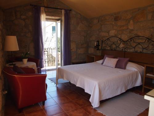 a bedroom with a large bed and a window at Casa das Magnólias de Igarei in Igarei