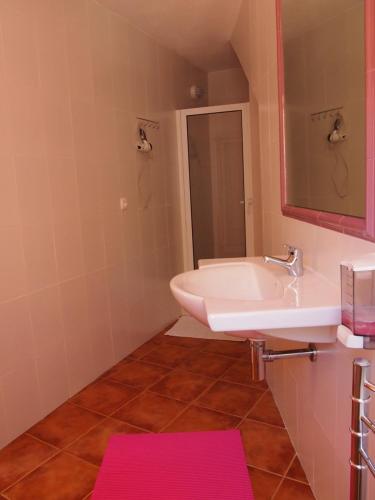baño con lavabo blanco y estera rosa en Casa das Magnólias de Igarei, en Igarei