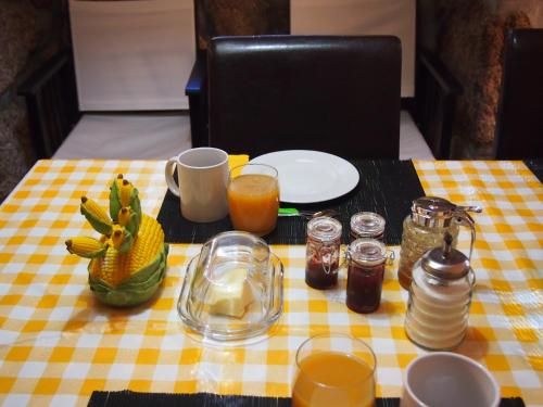 a table with a yellow and white checkered table cloth at Casa das Magnólias de Igarei in Igarei