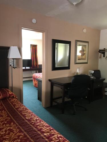 a hotel room with a desk and a bed at Townhouse Motel in Weed