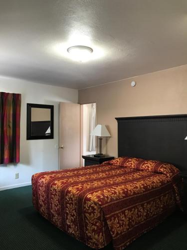 um quarto de hotel com uma cama e uma janela em Townhouse Motel em Weed