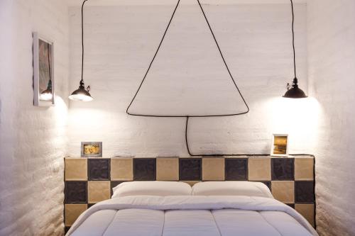 a bedroom with a bed with two lights above it at Rukka Lodge in Tumbaco