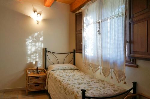 a bedroom with a bed next to a window at Taormina Villa Ibiscus Alcantara in Gaggi