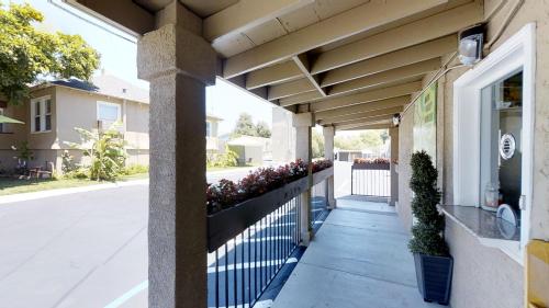 a porch of a building with a fence and flowers at Napa Discovery Inn in Napa