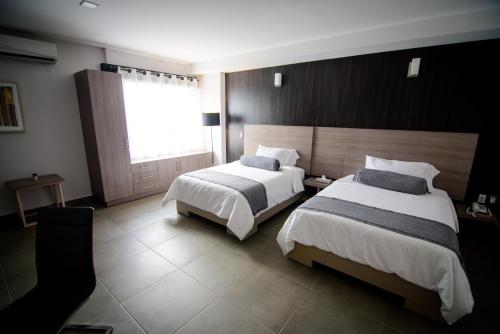 a hotel room with two beds and a window at Maria Ines Hotel Suite in Oaxaca City