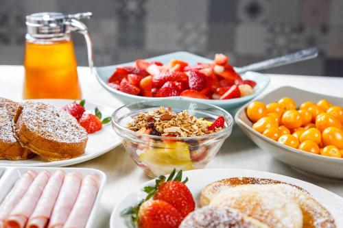 a table with plates of food and bowls of fruit at Rukka Lodge in Tumbaco
