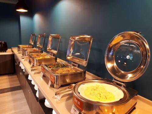 a row of trays of food on a buffet line at KUN Hotel in Taichung