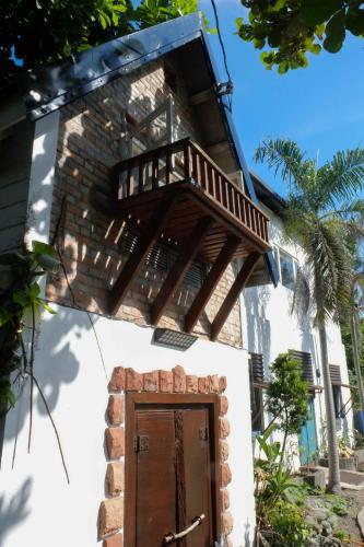 a building with a wooden door and a balcony at Bridge12th B&B in Yanliau